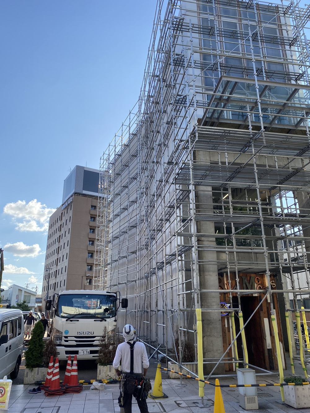 金沢市街地の商業ビルに組まれた外部足場と作業員