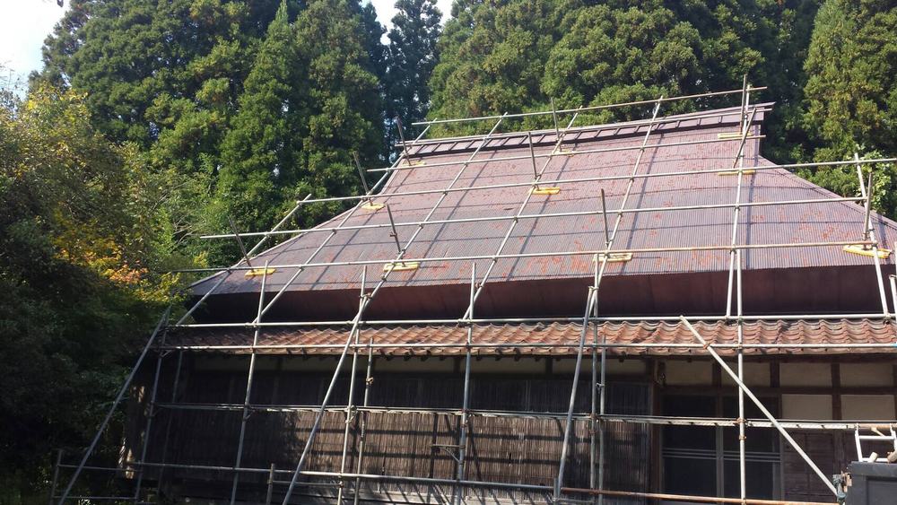 古民家の大屋根に沿って組まれた屋根足場
